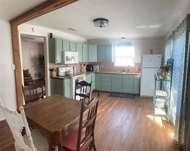 kitchen with decorative backsplash, dark hardwood / wood-style floors, sink, white appliances, and ceiling fan