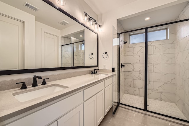 bathroom with a shower with door, vanity, and tile patterned floors