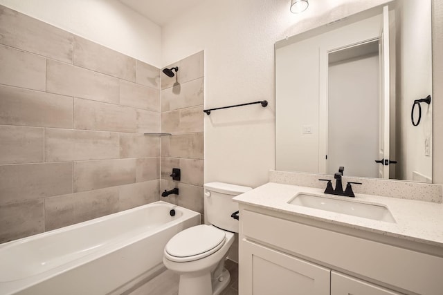 full bathroom featuring tiled shower / bath, vanity, and toilet