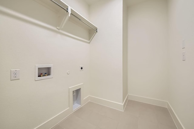 clothes washing area featuring electric dryer hookup, light tile patterned floors, hookup for a washing machine, and gas dryer hookup