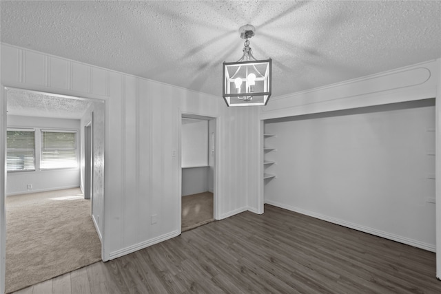 interior space featuring a textured ceiling, dark hardwood / wood-style floors, and a chandelier