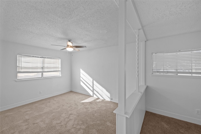 unfurnished room with a textured ceiling, light carpet, and ceiling fan