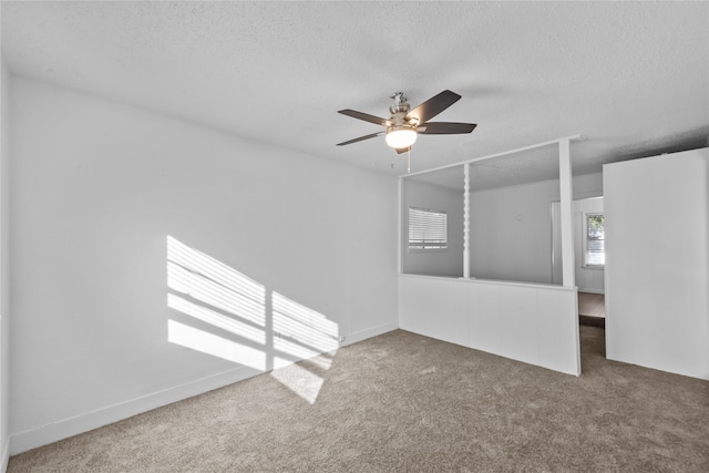 empty room with a textured ceiling, ceiling fan, and carpet floors