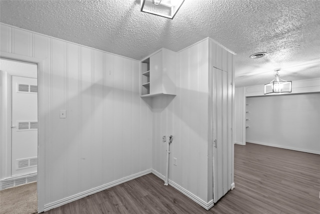 clothes washing area featuring dark hardwood / wood-style flooring and a textured ceiling