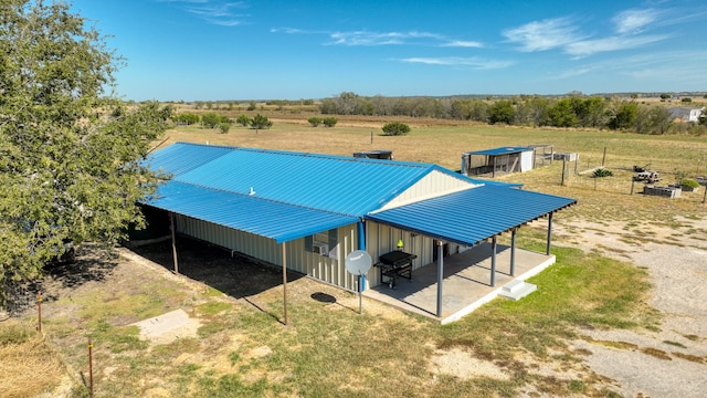 rear view of house with a rural view and an outdoor structure