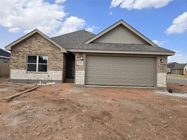 ranch-style home featuring brick siding, driveway, a shingled roof, and a garage