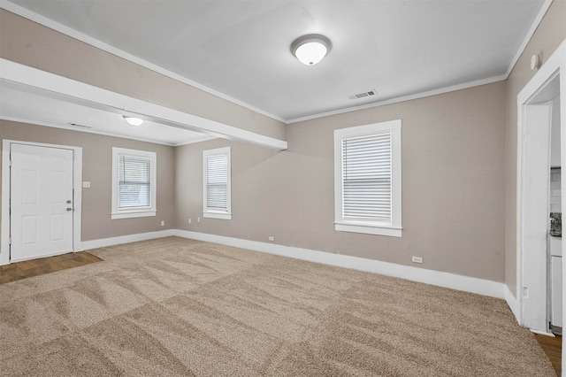 empty room with ornamental molding and carpet flooring