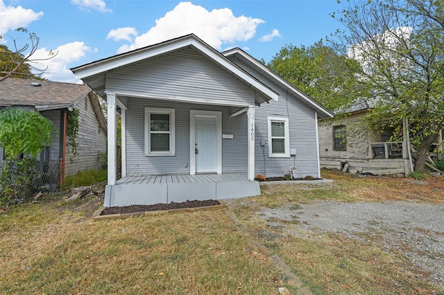 bungalow-style home featuring covered porch and a front lawn