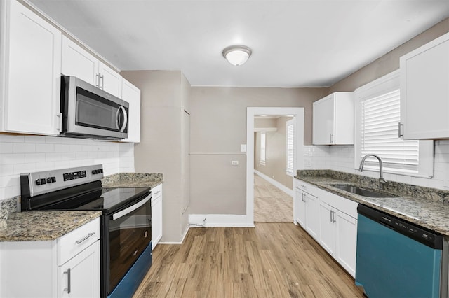 kitchen with sink, appliances with stainless steel finishes, and white cabinetry