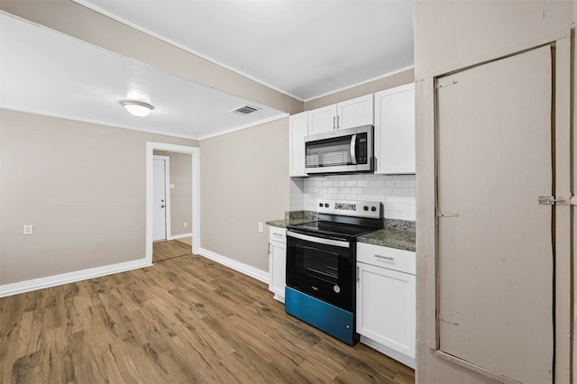 kitchen with appliances with stainless steel finishes, backsplash, white cabinetry, crown molding, and hardwood / wood-style flooring