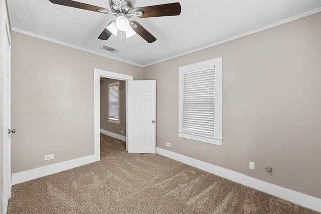 unfurnished bedroom with crown molding, carpet flooring, a textured ceiling, and ceiling fan