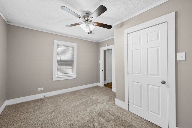 unfurnished bedroom with a textured ceiling, a closet, ceiling fan, light carpet, and ornamental molding