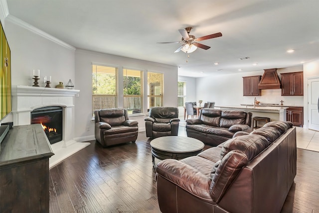 living room with sink, ceiling fan, ornamental molding, and dark hardwood / wood-style flooring