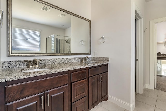 bathroom with vanity, a shower with shower door, and tile patterned floors