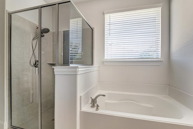 bathroom featuring independent shower and bath and a healthy amount of sunlight