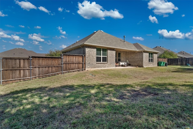 back of house with a patio area and a lawn