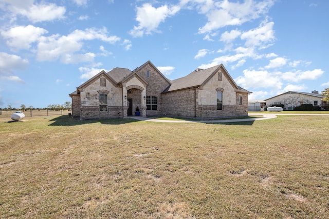 french provincial home with a patio and a front lawn