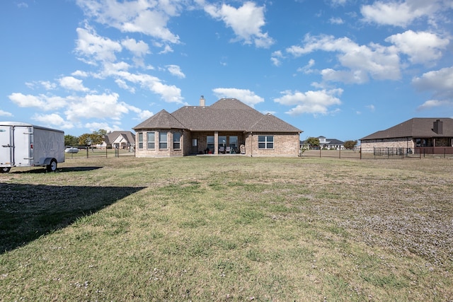 rear view of property with a yard and a storage shed