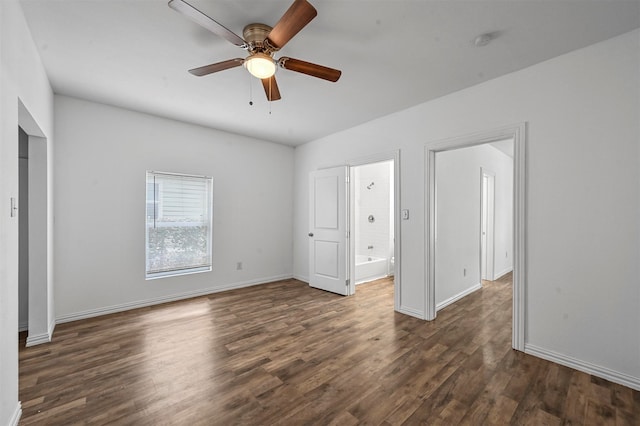 unfurnished bedroom with ensuite bath, dark wood-type flooring, and ceiling fan