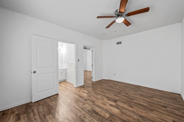 unfurnished bedroom with ensuite bath, dark wood-type flooring, and ceiling fan