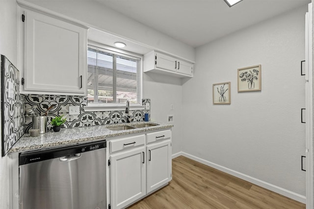 kitchen featuring dishwasher, backsplash, white cabinets, sink, and light wood-type flooring