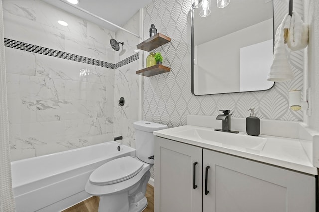 full bathroom featuring hardwood / wood-style flooring, vanity, toilet, and tiled shower / bath combo