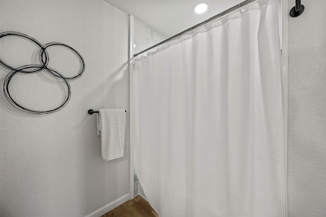 bathroom featuring wood-type flooring and walk in shower