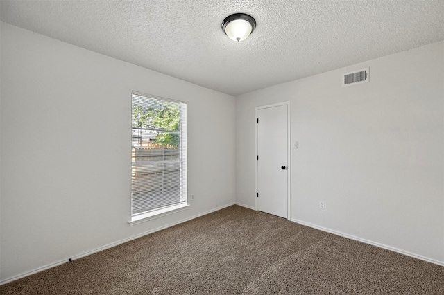 carpeted spare room featuring a textured ceiling