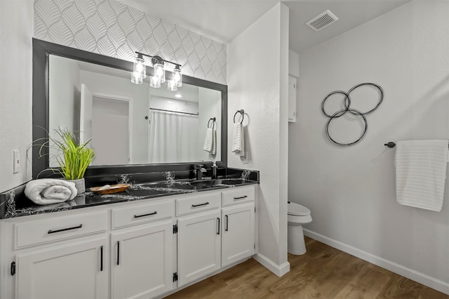 bathroom featuring hardwood / wood-style flooring, vanity, curtained shower, and toilet