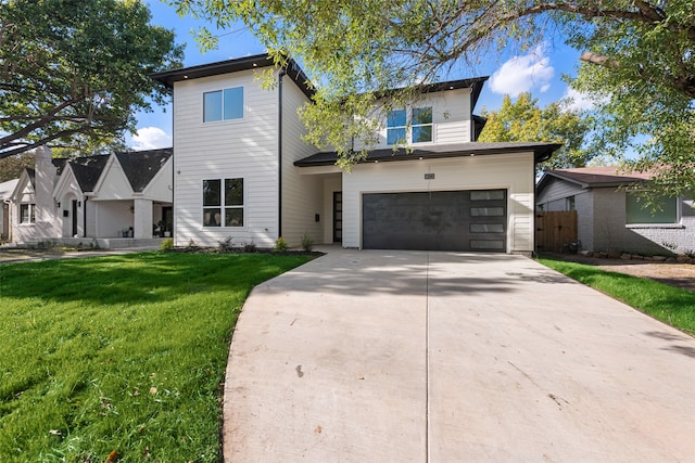 view of front of property featuring a front lawn and a garage