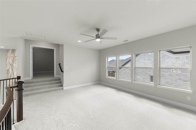 carpeted spare room featuring ceiling fan