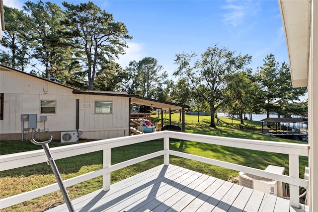 deck featuring ac unit and a lawn