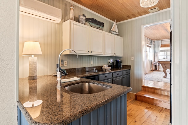 kitchen with a wall mounted AC, wood ceiling, kitchen peninsula, white cabinetry, and light hardwood / wood-style floors