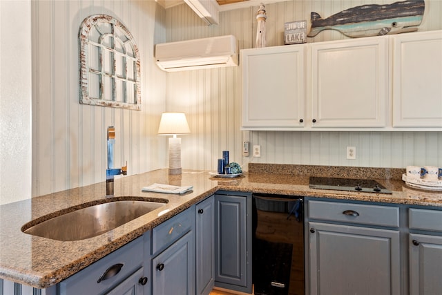 kitchen featuring an AC wall unit, dark stone counters, kitchen peninsula, and white cabinets