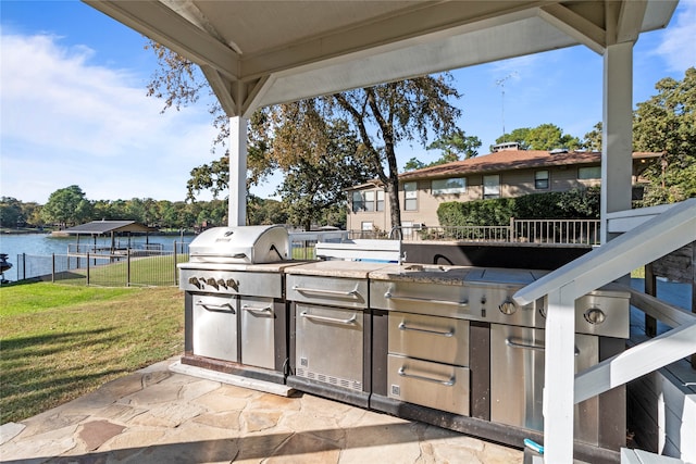 view of patio / terrace featuring a water view, area for grilling, and an outdoor kitchen