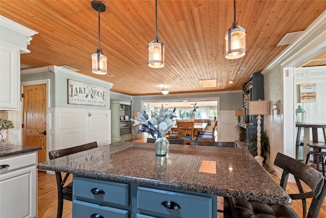 kitchen featuring light hardwood / wood-style floors, hanging light fixtures, a center island, and white cabinets