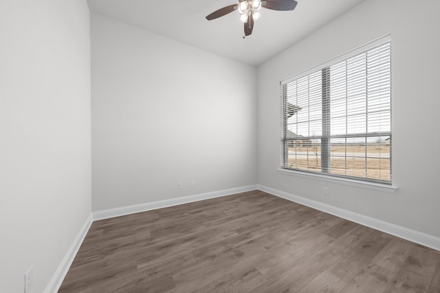 empty room with ceiling fan, baseboards, and wood finished floors