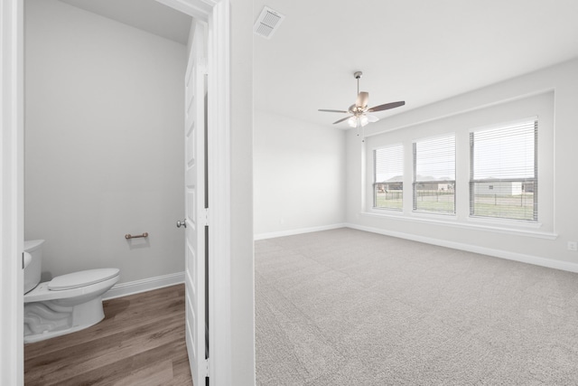 bathroom with toilet, baseboards, visible vents, and ceiling fan