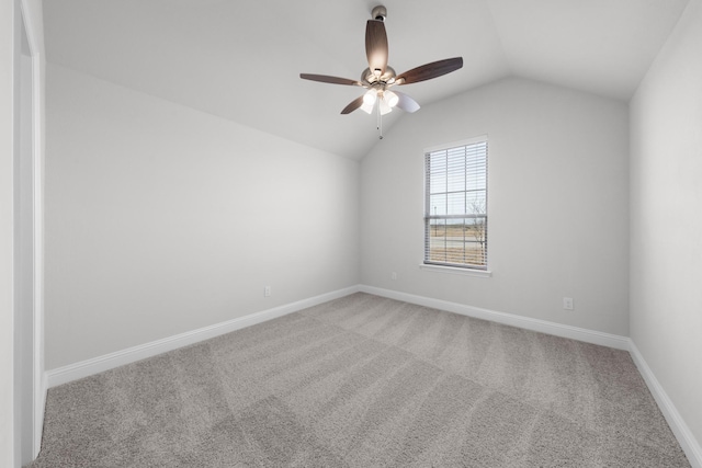 carpeted empty room featuring baseboards, lofted ceiling, and ceiling fan