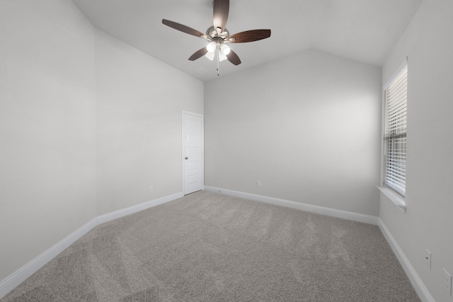 carpeted spare room with lofted ceiling, baseboards, and ceiling fan