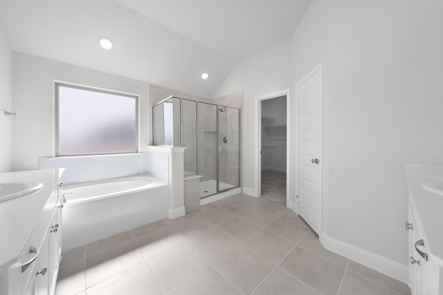 bathroom with tile patterned flooring, a spacious closet, a stall shower, and vanity