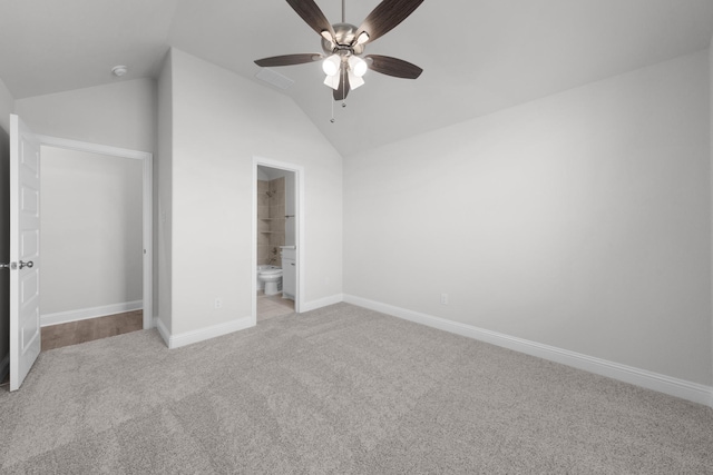 unfurnished bedroom with baseboards, carpet floors, lofted ceiling, and connected bathroom