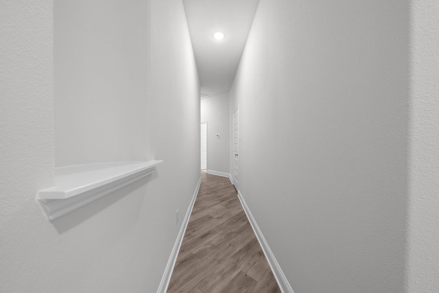 hallway with recessed lighting, baseboards, and wood finished floors