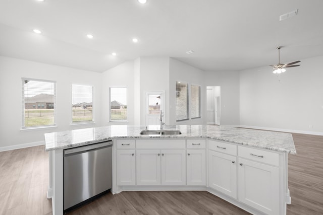 kitchen featuring light wood-style flooring, a sink, light stone counters, open floor plan, and dishwasher