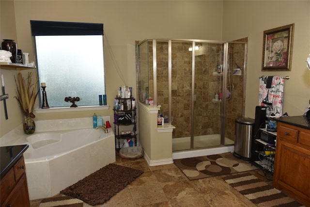 bathroom with vanity and shower with separate bathtub