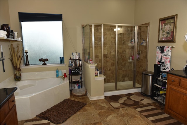 bathroom with vanity and independent shower and bath