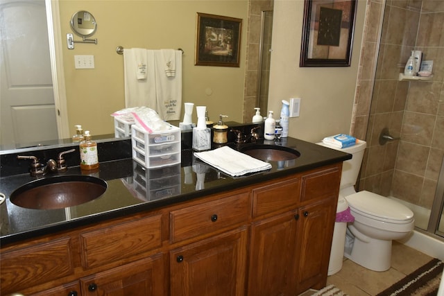 bathroom featuring walk in shower, vanity, toilet, and tile patterned flooring