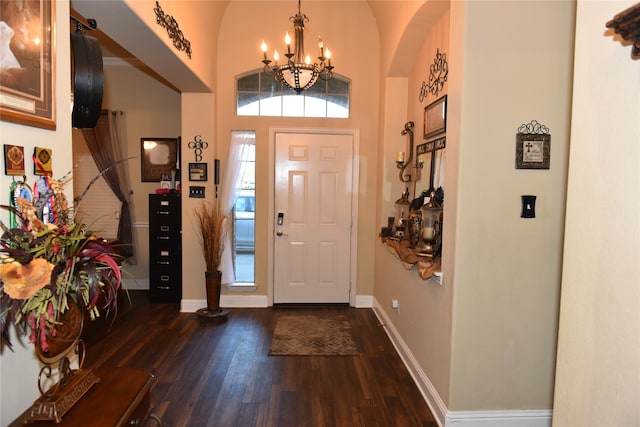 foyer featuring vaulted ceiling, dark hardwood / wood-style floors, and a notable chandelier