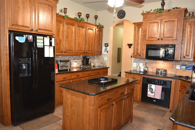 kitchen with a center island, light tile patterned floors, ceiling fan, decorative backsplash, and black appliances