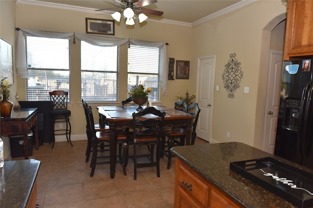 tiled dining area with ceiling fan, a healthy amount of sunlight, and ornamental molding